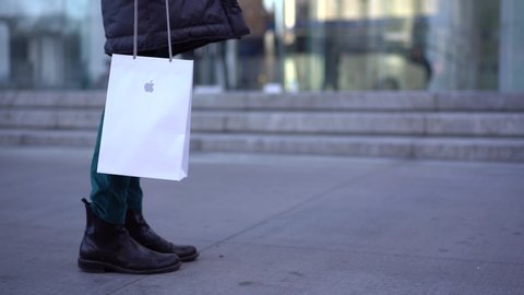 NEW YORK - FEBRUARY, 2020: Woman holding Apple shopper in the street. Apple Inc. is an American multinational technology company headquartered in Cupertino, California.