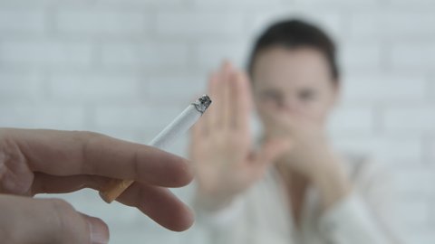 Quit smoking. A female stop smoking when she saw a cigarette in the man's hand.