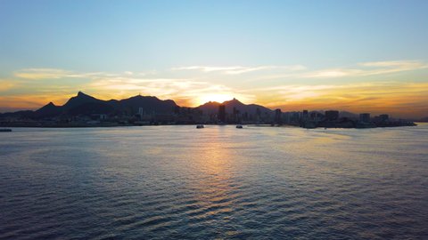Aerial View Drone Footage of Sea With Sunset in Rio De Janeiro, Brazil. 4K 60fps Sunset Sugar Loaf and Christ Redeemer.  Ocean Sugar Loaf (Pão de Açúcar) &Christ Redeemer (estátua do Cristo Redentor)