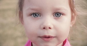 Portrait of pretty little girl with big blue eyes screams and coughs