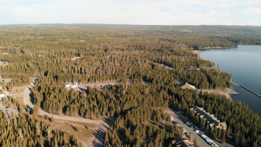 Amazing sunrise aerial view of Yellowstone Lake with trees and car parking, Wyoming.
