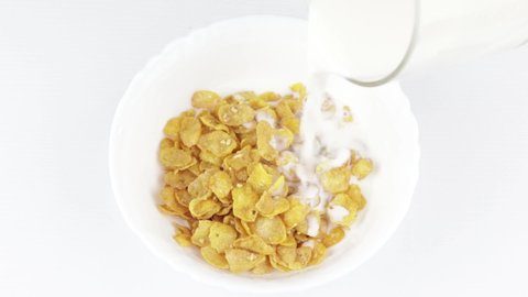white plate is filled with cornflakes and filled with milk, a healthy food concept