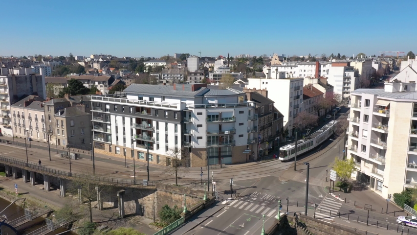 France, Nantes, tramway running in the street close to Erdre river, drone aerial view