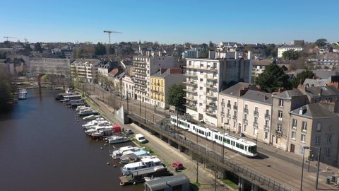 France, Nantes, tramway running in the street close to Erdre river, drone aerial view