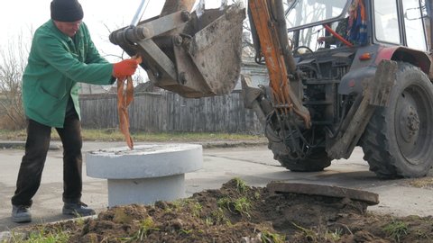 Installation of covers of cable shafts. Using an excavator tractor.