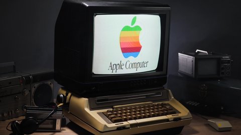 Zooming out on Apple Logo on a vintage monitor with retro technology around the desk. Old tech concept. MONTREAL - CANADA - MARCH 2020