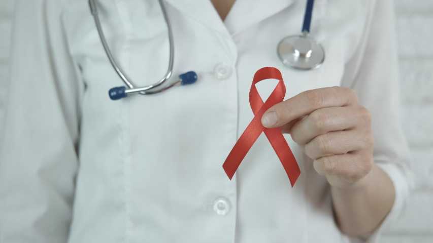 Ribbon against AIDS. A view of a doctor with an awareness ribbon against AIDs. | Shutterstock HD Video #1049091964