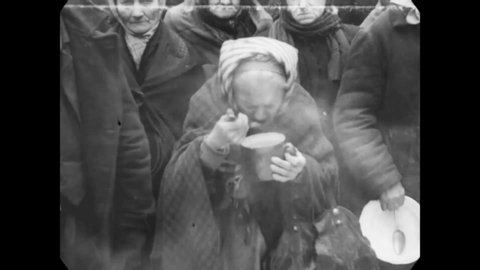 CIRCA 1919 - Men and women receive soup at wintertime in a soup kitchen in Prague, Czechoslovakia.