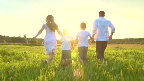 Happy Young Family with two children running on summer field. Healthy mother, father and little sons enjoying nature together, outdoors. Sunset. Slow motion 240 fps, high speed camera, Full HD 1080p 