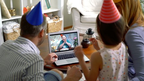 A family with a child congratulating a grandmother on her birthday using a video call. Home quarantine, social distancing, self isolation.