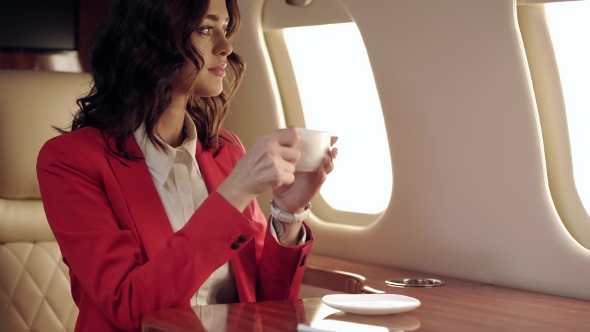 happy businesswoman drinking coffee while traveling by plane Royalty-Free Stock Footage #1049107429