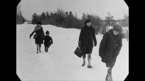 CIRCA 1923 - Children walk to school in rural Ontario, Canada in the snow, while others arrive in a horse-drawn sleigh.
