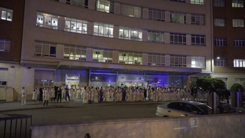 MADRID, SPAIN - MARCH 25 2020. Medical staff from the Fundacion Jimenez Diaz hospital who are fighting coronavirus applaud back the people of Madrid and police officers for their support