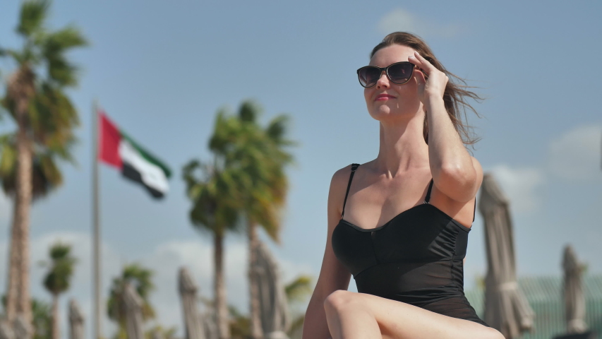 Girl on the beach posing against the backdrop of the UAE flag in Dubai