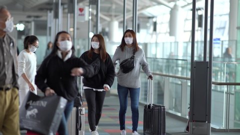 Nagoya, Japan - Feb. 3, 2020: Unidentified passengers wearing mask are seen walking to gate at Chubu Centrair International Airport. The Covid-19 pandemic just started at this time.