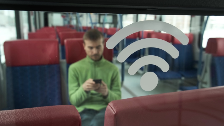 Wi-Fi sign inside modern train and person using smartphone in the background. Accessible urban environment. People and gadgets in the city.