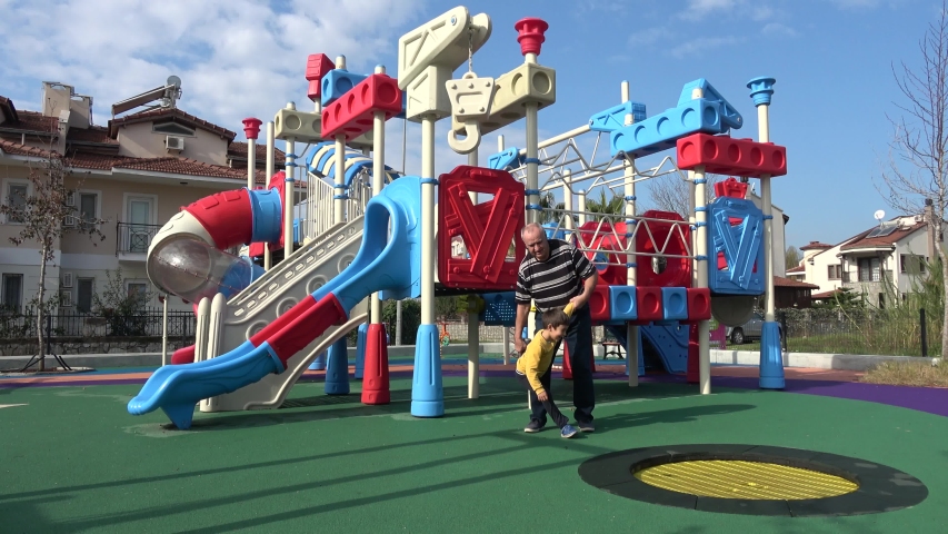 Fethiye, Turkey - 18th of January 2020: 4K Granddad playing spins his grandson around holding by hands and leg
