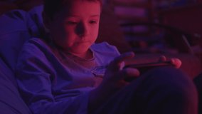 Cute small boy looks at a smartphone before going to bed in a dark room play games talk bedroom technology bed child smartphone cellphone night internet mobile gadget slow motion
