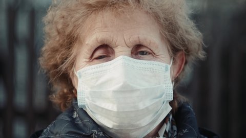elderly woman in a respirator protection mask is walking the street. Quarantine coronavirus covid-19 for old people. Retirement Health at Risk, granny in mask