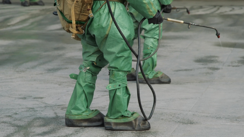 Workers in bio viral hazard protective suits disinfects floor and surfaces from coronavirus. Antibacterial sanitary measures on quarantine. UltraHD 4K