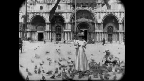 CIRCA 1896 - People and trolleys are seen in Cathedral Square of Milan, and women feed pigeons in Venice.