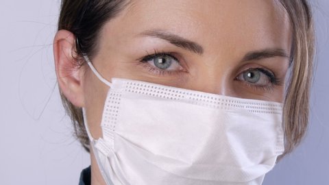 Portrait Beautiful young woman with tousled hair tired eyes in medical mask on a white background close-up view. Nurses, medical staff during epidemic. Health care Coronavirus and medical concept