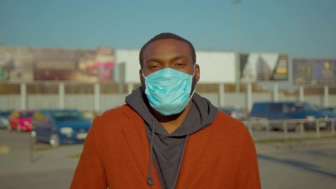 African American man wearing Protective Face Mask to avoid disease COVID-19 coronavirus infection look at camera near airport pandemic disease virus male tourist epidemic air health illness slow