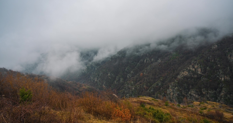 Time lapse of fog and clouds rolling over the mountain autumn hills