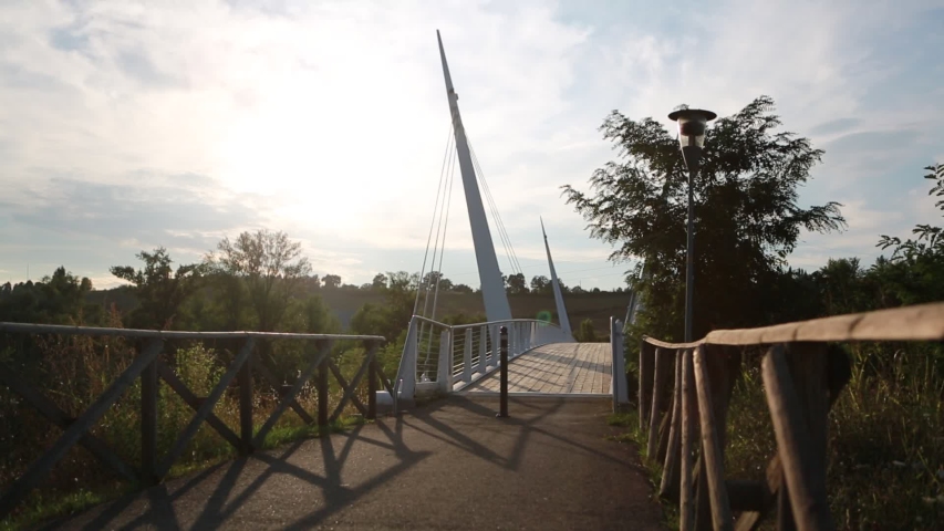 bridge over the river secchia in sassuolo modena with wooden walkway at sunset with cyclist
