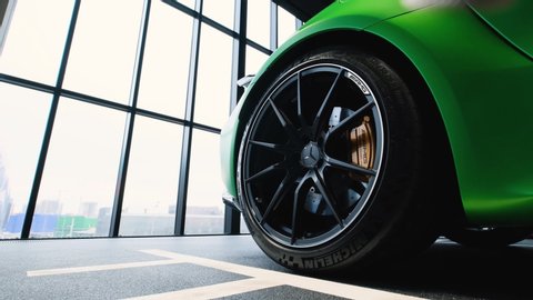 Moscow, Russia - February, 2020: The new Mercedes-Benz GT-R AMG a luxury sport car in a dealer showroom. Closeup view of a wheel and rim