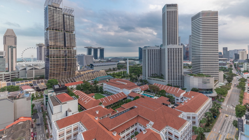 Evening panorama with Marina Bay area and skyscrapers city skyline aerial timelapse. The tower shape building at the North bridge road with traffic in Singapore.