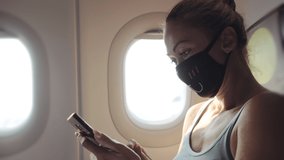 Woman travel tourist caucasian at plane aircraft with wearing protective medical mask. Read shock news about coronovirus at smartphone mobile. Virus coronavirus epidemic sars-cov-2 covid-19 2019-ncov. - Powered by Shutterstock - Get 15% off with code: PIKWIZARD15
