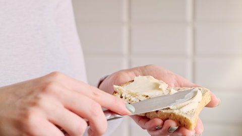 Female hands making a sandwich. Woman preparing breakfast, putting cheese on toast bread.