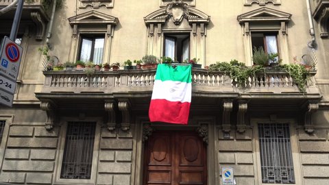 Europe, Italy , Milan - Flag of Italy hanging on the balcony of a house during covid-19 Coronavirus epidemic emergency - Italian flash mob