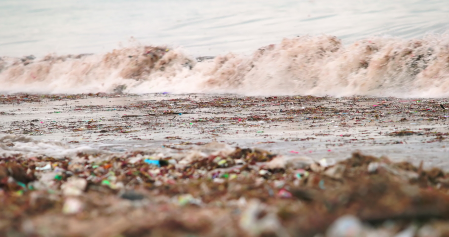 The worlds most polluted beach in Bali. Plastic bags bottles and paper trash on the sandy dirty beach. Sea waves full of litter hitting the beach. Huge dump in tropical paradise. Marine pollution. Royalty-Free Stock Footage #1049310775