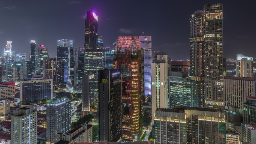 Aerial cityscape of Singapore downtown of modern architecture with illuminated skyscrapers night timelapse, view from above from skybridge viewpoint with glowing windows in towers
