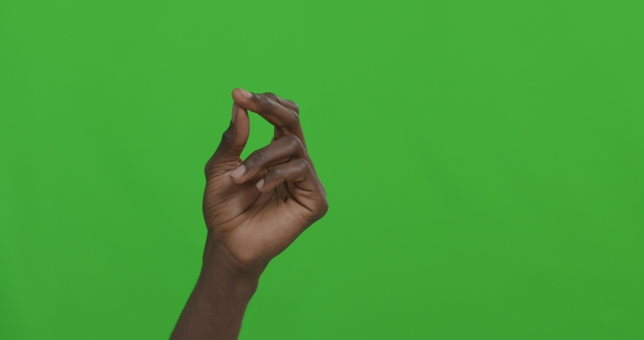 Black man snapping his fingers over green chroma key background. 4k Royalty-Free Stock Footage #1049311219