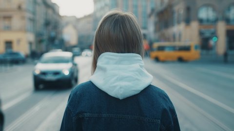 Close up view of a sad young girl walking wearing in medical mask on the street road outdoor. Concept of health and safety life covid19 coronavirus virus protection pandemic city side view