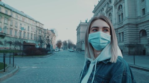 Young women female walking across the road city wearing medical mask to be safe coronavirus covid19 pandemic virus protection life close up