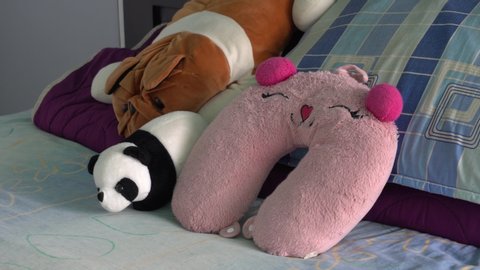 close-up of various pillows and stuffed animals on a bed. a nice and cozy place to rest and sleep