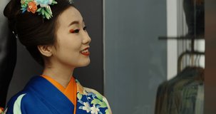 Portrait shot of beautiful asian girl wearing traditional japanese kimono dress in elevator in public place, looking at camera and smiling - traditional culture in modern japan 4k footage