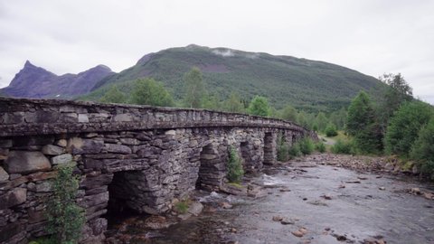 Old stone bridge with a high sharp mountain peak in the background - Norwegian mountain scenery