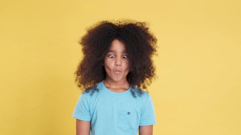 Humorous or Comical Face of Little African American Girl with Curly Hair. Funny and Idiotic Facial Expressions. Imagine Fish Face. Charismatic and Artistic Kid Have Fun and Shows Grimaces.