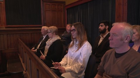 Jury sat in Courtroom during court case. They are listening to the facts from the legal proceedings. and look unimpressed. Stock Video Clip Footage
