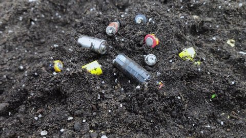 Used batteries in the ground. Hazardous waste polluting the environment. The concept of environmental protection and the recycling of batteries and batteries
