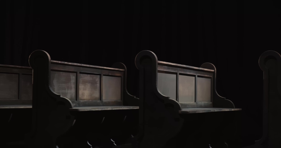 Smooth tracking shot of church pews/benches in a row, forward and backward. Dark background. 4K (4096x2160p) | Shutterstock HD Video #1049360572