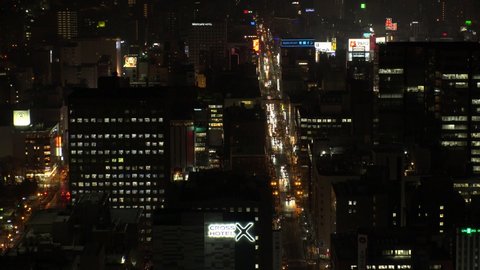 SAPPORO, HOKKAIDO, JAPAN - FEB 2020 : Aerial high angle view of cityscape of Sapporo city at night. View of buildings and street traffic around Susukino downtown area.