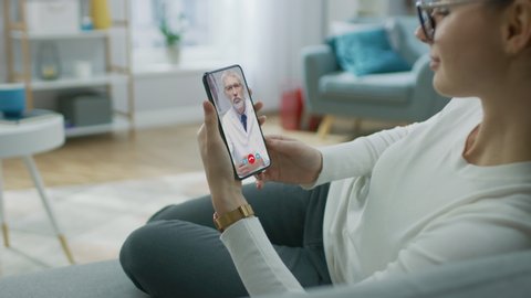 Young Girl Sick at Home Using Smartphone to Talk to Her Doctor via Video Conference Medical App. Beautiful Woman Checks Possible Symptoms with Professional Physician, Using Online Video Chat