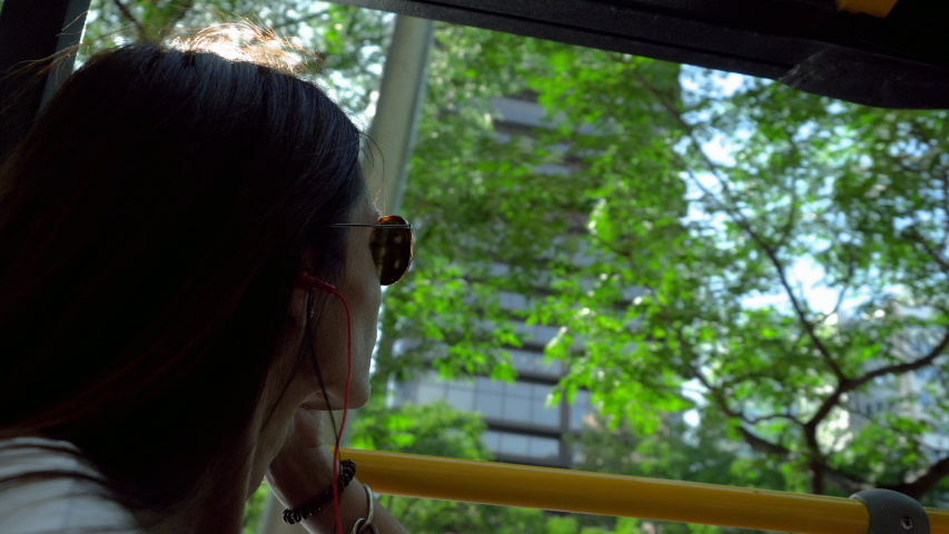 Close-up shot of young attractive woman looking around on landmarks of Madrid in excursion bus. Spain. 4K
