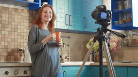 Food blogger girl influencer is recording a video or podcast in the kitchen. Woman is drinking morning coffee in the kitchen. A woman communicates with subscribers, asks to like the video